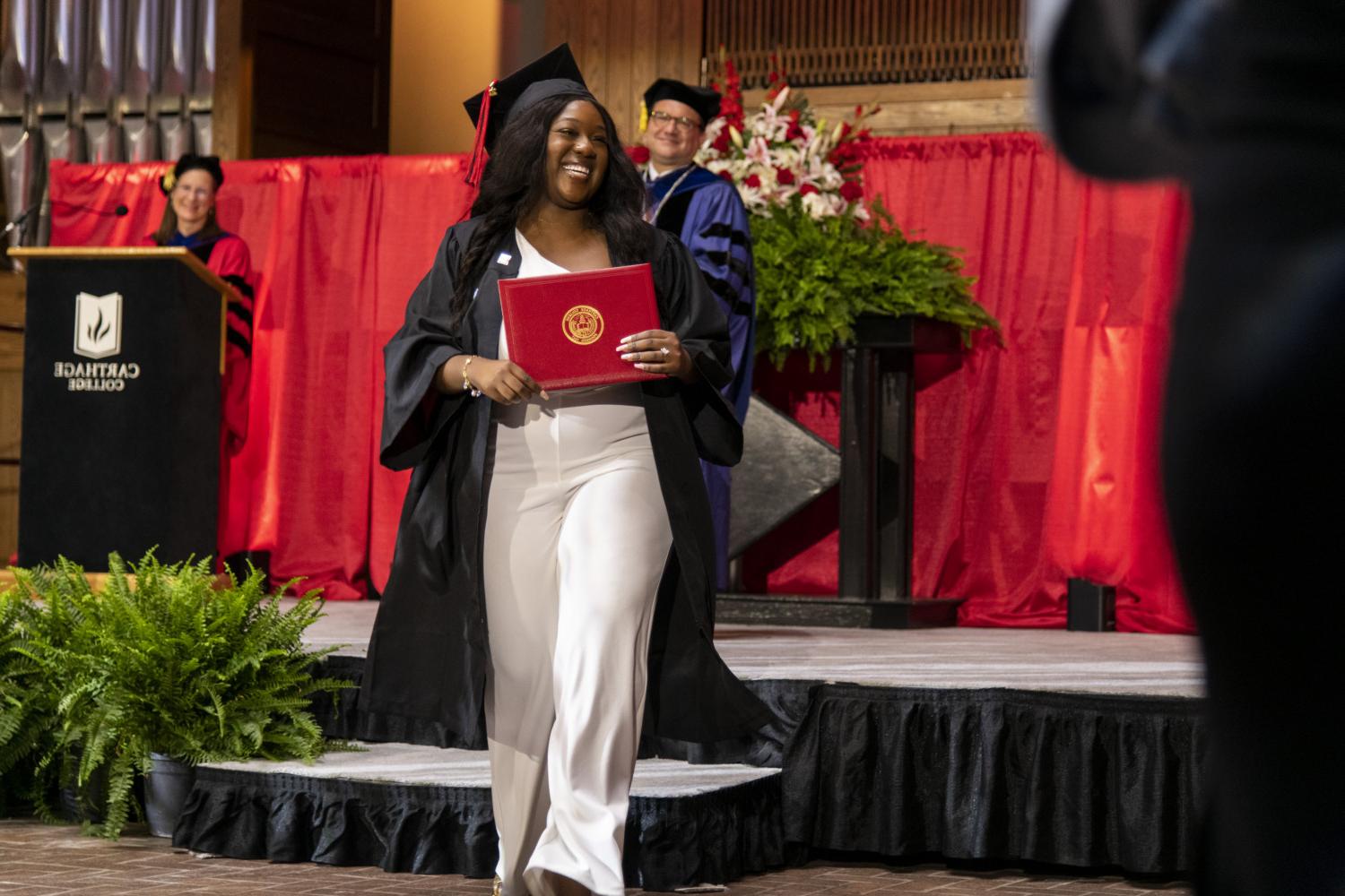 A 2023 <a href='http://nz.typewritersandtelegrams.com'>全球十大赌钱排行app</a> graduate beams as she leaves the Commencement stage after receiving her diploma from Carthage President John 吞下.